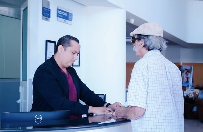 Recepción atendiendo a un paciente
